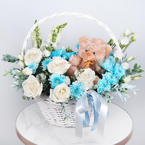White Matthiola - 2, White rose 50 cm - 7, Chrysanthemum spray Baltica painted blue - 3, White spray carnation - 3, lisianthus - 2, Medium Basket, Oasis, Pistachio, Teddy bear 20 cm, Ribbon