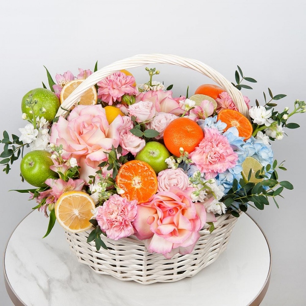 Rose Esperance - 3, Pink carnation - 11, Blue/purple hydrangea - 1, Alstromeria white, soft pink - 7, Peony sprayrose - 2, White Matthiola - 3, Large Basket, Oasis, Eucalyptus, Apple, 1 pc., Tangerine, 1 pc., Lemon, 1 pc., Wooden skewer, Film