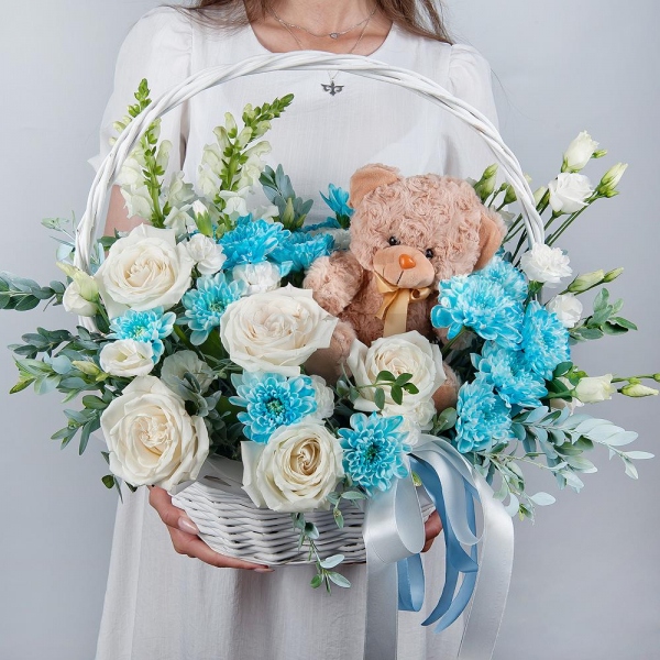 White Matthiola - 2, White rose 50 cm - 7, Chrysanthemum spray Baltica painted blue - 3, White spray carnation - 3, lisianthus - 2, Medium Basket, Oasis, Pistachio, Teddy bear 20 cm, Ribbon