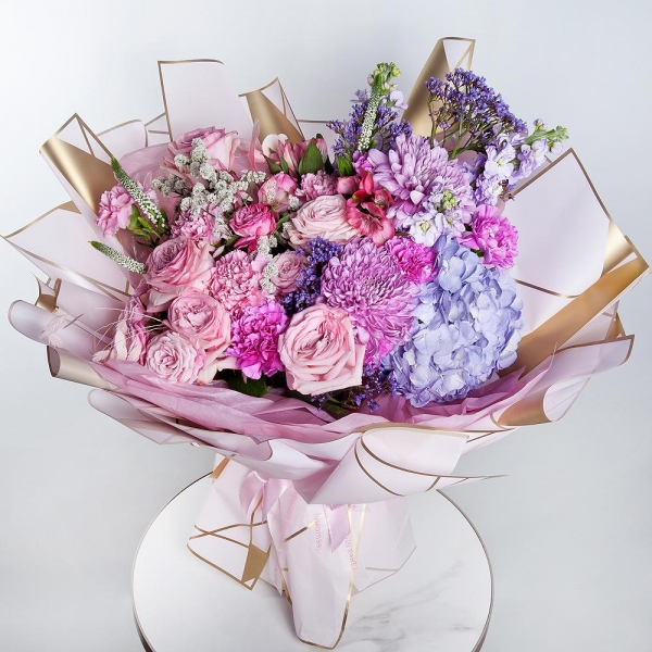 Blue/purple hydrangea - 1, Magnum Purple Chrysanthemum - 2, Matthiola Lilac - 4, Lilac carnation - 10, Peony sprayrose - 5, Peony rose pink 'OHara' - 5, Alstromeria white, soft pink - 11, Pink carnation - 11, Limonium (1 pc.), Veronica spray, Dried flowers in assortment, Wrapping Paper