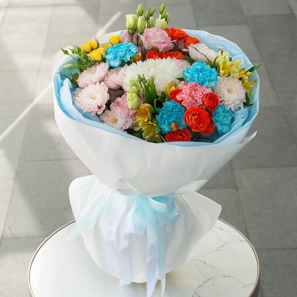 Baltica Pink Spray Chrysanthemum - 2, Magnum White Chrysanthemum - 1, Pink carnation - 2, Carnation white, cream - 5, Pink Lisianthus (Eustoma) - 2, Alstromeria Yellow, Orange - 5, Spray rose: yellow, orange 50 cm - 3, Wrapping Paper