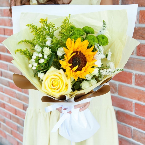 Sunflower - 1, Yellow rose 50 cm - 1, Spray rose: white, cream, light pink 50 cm - 3, Athos poms Green Lizard - 1, Santini White Spray Chrysanthemum - 2, Solidago (1 pc.), Hypericum, Veronica spray, Pistachio, Wrapping Paper