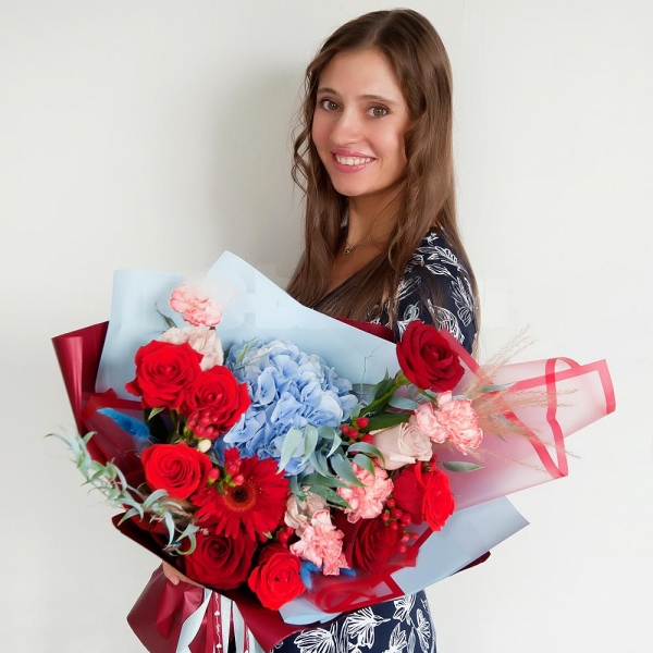 Gerbera red - 2, Blue/purple hydrangea - 1, Pink carnation - 9, Red rose 50 cm - 10, Rose Cream 50 cm - 5, Hypericum, Ruscus italian, Dried flowers in assortment, Wrapping Paper
