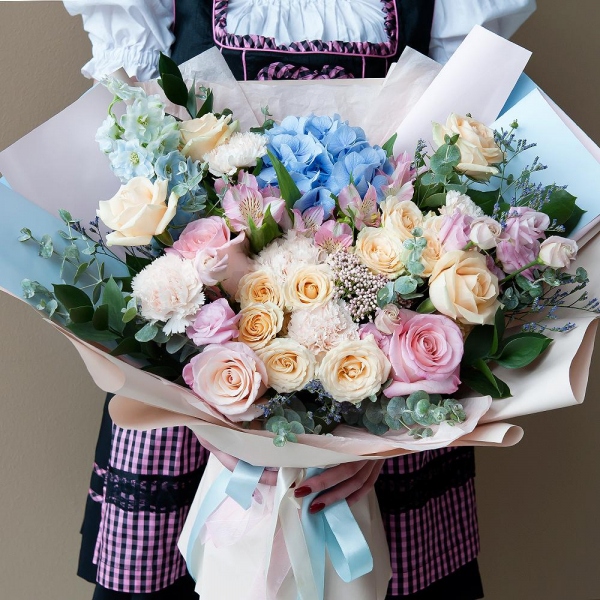 Blue/purple hydrangea - 1, Pink rose 50 cm - 4, Spray rose: white, cream, light pink 50 cm - 3, Rose Cream 50 cm - 5, Alstromeria white, soft pink - 4, Carnation white, cream - 7, Pink Lisianthus (Eustoma) - 2, Ozotamnus, Limonium (1 pc.), Blue Delphinium, Ruscus, Eucalyptus, Wrapping Paper