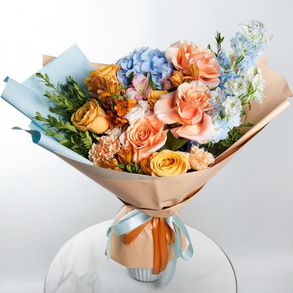 Blue/purple hydrangea - 1, Cream Rose 50 cm Ecuador (Creme Caramel) - 4, Rose Cream 50 cm - 5, Spray rose: white, cream, light pink 50 cm - 3, Carnation white, cream - 7, Alstromeria Yellow, Orange - 4, Alstromeria white, soft pink - 3, Blue Delphinium, Pistachio, Wrapping Paper